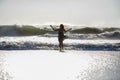 Silhouette of young happy Asian woman relaxed looking at wild sea waves on sunset tropical beach Royalty Free Stock Photo