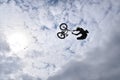 Silhouette of a young man freestyle stunt cyclist flying in the sky