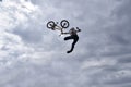 Silhouette of a young man freestyle stunt cyclist flying in the sky