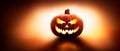 A back lit halloween lantern, Jack o Lantern, with a spooky evil face with glowing eyes