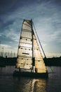 Sailboat in Front of Sun in Harbor Royalty Free Stock Photo