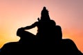 Back lit statue of hindu god lord shiva in meditation posture with dramatic sky from unique angle Royalty Free Stock Photo