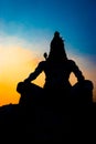 Back lit statue of hindu god lord shiva in meditation posture with dramatic sky from unique angle Royalty Free Stock Photo