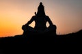 Back lit statue of hindu god lord shiva in meditation posture with dramatic sky from unique angle Royalty Free Stock Photo