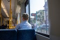 Back of male passenger with face protection mask who sit in light rail tram or train in Germany.