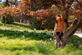 Back of man leaning against a tree in park Royalty Free Stock Photo