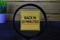 Back in 10 Minutes write on sticky notes isolated on wooden table Royalty Free Stock Photo