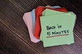 Back in 5 Minutes write on sticky notes isolated on Wooden Table