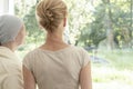 Back of mother with cancer and daughter looking through the window Royalty Free Stock Photo