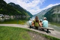 Back of mother with four children sit on bench over Austrian alps lake in Hallstatt, Salzkammergut, Austria Royalty Free Stock Photo