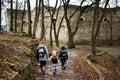 Back of mother and kids walk path to an ancient medieval fortress in rain. Terebovlia castle, Ukraine