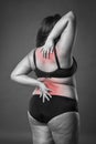 Back and neck pain, fat woman with backache, overweight female body on gray background Royalty Free Stock Photo