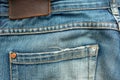 Back of old blue jeans with pocket and a leather tag. Close-up photo Royalty Free Stock Photo