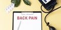 BACK PAIN on the Document with yellow background. Healthcare