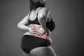 Back pain, fat woman with backache, overweight female body on gray background Royalty Free Stock Photo