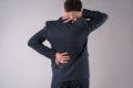 Back pain, office worker with backache on gray background Royalty Free Stock Photo