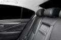 Back passenger seats in modern luxury car, frontal view. Black perforated leather with white stitching. Car detailing. Leather com Royalty Free Stock Photo