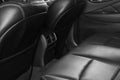 Back passenger seats in modern luxury car, frontal view. Black perforated leather with white stitching. Car detailing. Leather com Royalty Free Stock Photo