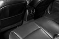 Back passenger seats in modern luxury car, frontal view. Black perforated leather with white stitching. Car detailing. Leather com Royalty Free Stock Photo