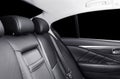 Back passenger seats in modern luxury car. Frontal view. Black perforated leather with white stitching. Car detailing. Leather com Royalty Free Stock Photo