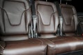 Back passenger seats in modern luxury car. Frontal view. Brown perforated leather with white stitching. Car detailing. Back Leathe Royalty Free Stock Photo