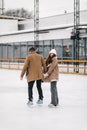 Happy family in a figure skating field heaving fun in warm coat