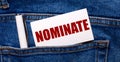 The back pocket of blue jeans contains a white pen and a white card with the text NOMINATE Royalty Free Stock Photo