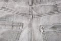 Back pocket of used grey jeans, grunge clothes close up Royalty Free Stock Photo