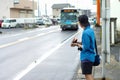 Back portrait of unidentified male tourist waiting for coming bus.