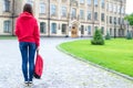 Back rear behind full length bosy size photo of serious confident concentrated hipster holding schoolbag in hand looking at the