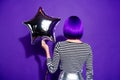 Back rear side photo of charming lady holding star-shaped baloon isolated over purple violet background