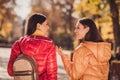 Back rear spine view photo of two fellows girls enjoy travel town countryside center walk fall park tell say listen news