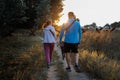 couple walking with dog in summer, spring park at sunset. Royalty Free Stock Photo