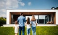 back, rear view of family with two 2 kids, children 4 four persons standing looking of new illuminated modern futuristic house Royalty Free Stock Photo