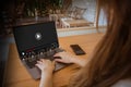 Back rear view of woman using laptop computer in the cafe streaming online, watching video on internet, live concert, show or Royalty Free Stock Photo