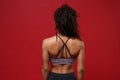 Back rear view of young african american sports fitness woman in sportswear posing working out isolated on red Royalty Free Stock Photo