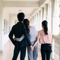 Back scene of two women with one man standing, sign of love triangle