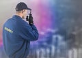 Back of security guard with walkie talkie against blurry wall with city sketch