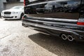 Back of a shiny black suburban wehiclecovered with water droplets. White car on the background. Advertisement concept Royalty Free Stock Photo