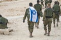 Back shot of several soldiers of israel army walking with israel national flag. Military man bearing israel flag on his shoulder Royalty Free Stock Photo