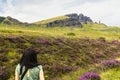 Back shot of a young brown-haired Caucasian woman standing calmly observing the beautiful landscape in the Scottish Highlands, Royalty Free Stock Photo