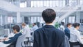 Back Shot of a Young Manager Walking Pass His Business Colleagues and Supervise Their Work. Diverse Royalty Free Stock Photo