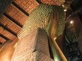 Back side of giant golden Reclining Buddha statue. Royalty Free Stock Photo