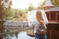 Back side of traveler girl searching right direction on map, orange sunset light, traveling along Europe Royalty Free Stock Photo