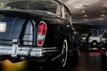 Back and side view of a white modern sport car with right backlight, trunk, whitewall tire on brown floor Royalty Free Stock Photo