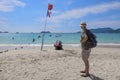 Hipster Asian young man traveler with sun hat and backpack on exotic white sand beach Royalty Free Stock Photo