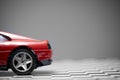 Back side view of a Red toy Ferrari 348TB sports car close up product shot on a chequered ground and gray background Royalty Free Stock Photo