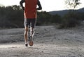 Sport man with ripped athletic and muscular legs running uphill off road in jogging training workout Royalty Free Stock Photo