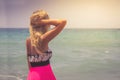 A back side view on a wonderful young woman watching to sea and raising her hands on sunrise Royalty Free Stock Photo