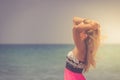 A back side view on a wonderful young woman watching to sea and raising her hands on sunrise Royalty Free Stock Photo